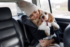 Mujer viajando en el asiento trasero de un taxi con su perro en brazos durante un trayecto por el Vallès Oriental