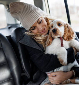 Mujer viajando en el asiento trasero de un taxi con su perro en brazos durante un trayecto por el Vallès Oriental