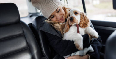 Mujer viajando en el asiento trasero de un taxi con su perro en brazos durante un trayecto por el Vallès Oriental