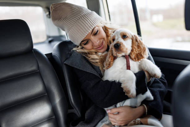 Mujer viajando en el asiento trasero de un taxi con su perro en brazos durante un trayecto por el Vallès Oriental
